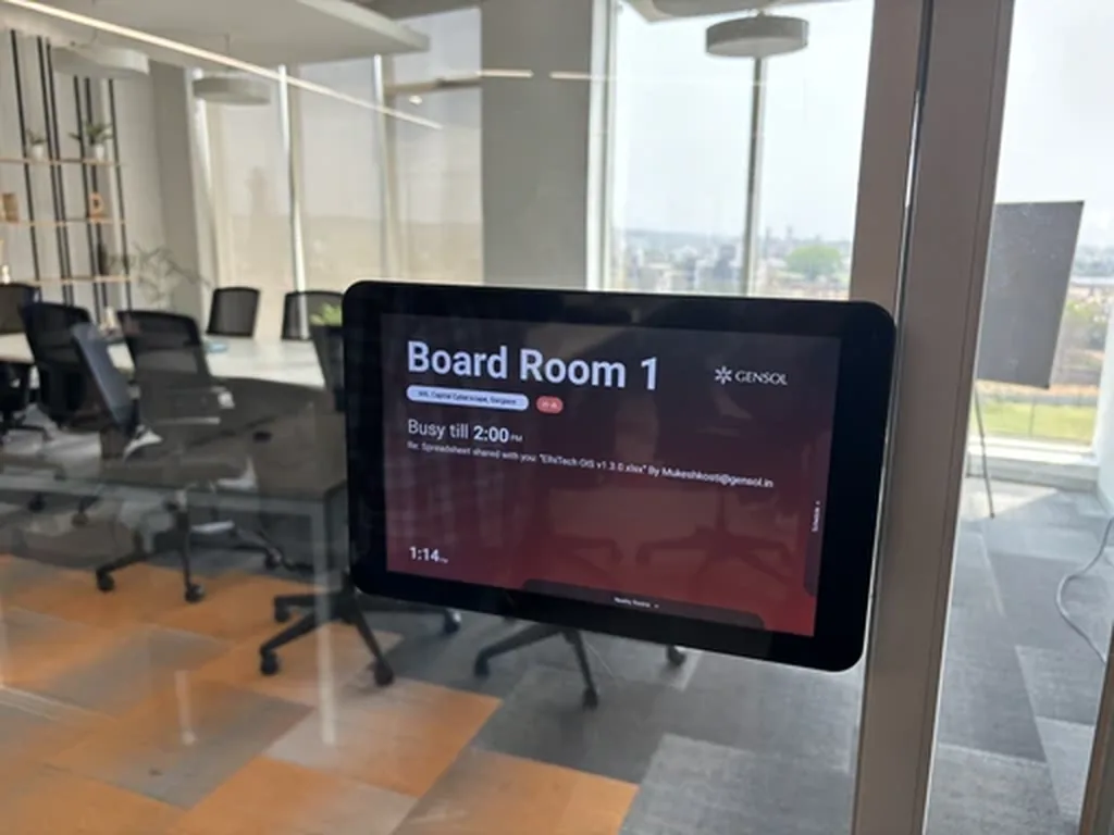 A truRooms e-paper room panel mounted on the glass wall of a board room at Gensol.