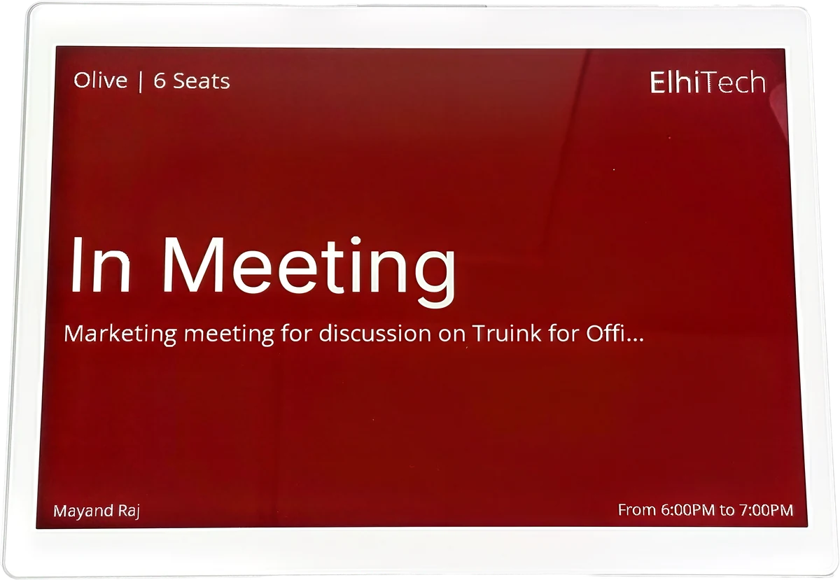 A truRooms e-paper room panel reading In Meeting, with the room name, the organiser and the booking window.